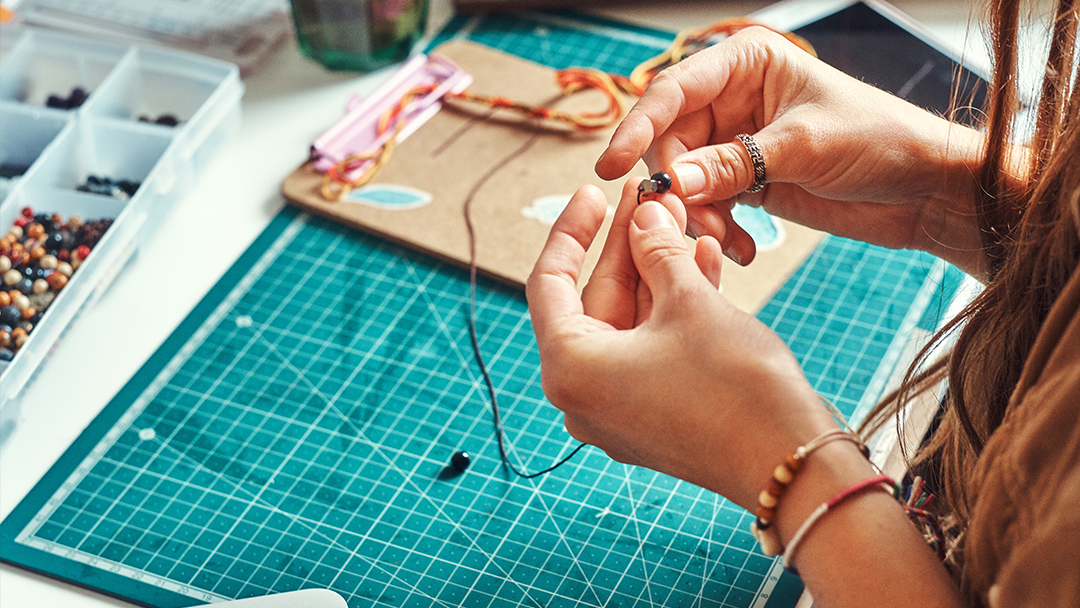 A creative girl creating jewellery from beads and stones.