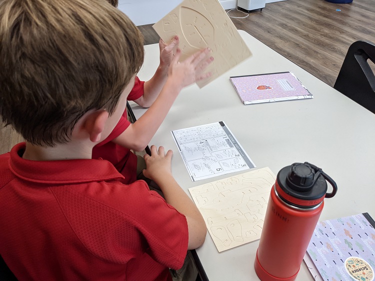 Two third-grade children assembled an animal model while discussing.